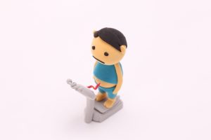 体重計に乗る男性の人形